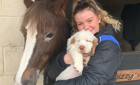 Emily Dinning with a horse, holding a dog